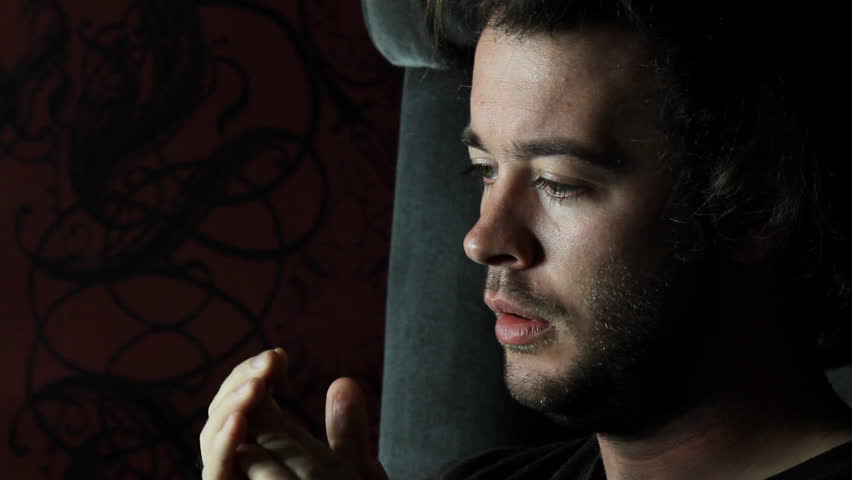 Man prays alone in dark room