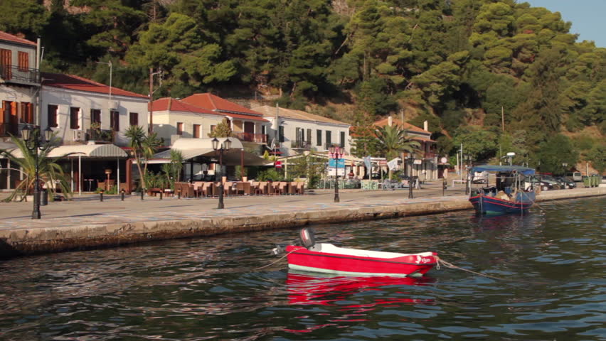 VONITSA AMBRACIAN GULF, GREECE - SEPTEMBER 29: Red pleasure boat bobs in the water at the town quay on September 29, 2012 in Vonitsa. The town is a typical picturesque Greek fishing village.