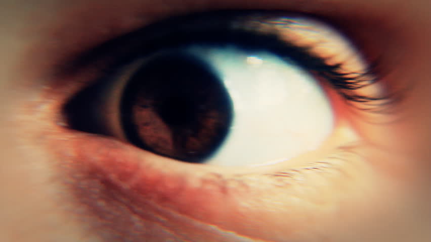 Close-up of the eye of a man awakened abruptly and having a frightened reaction, looking around.