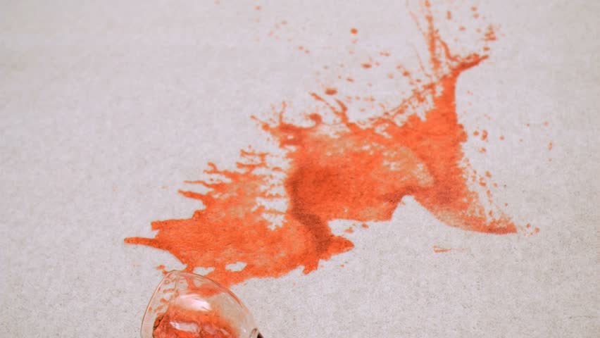 Beverage in wine glass falling in super slow motion on carpet