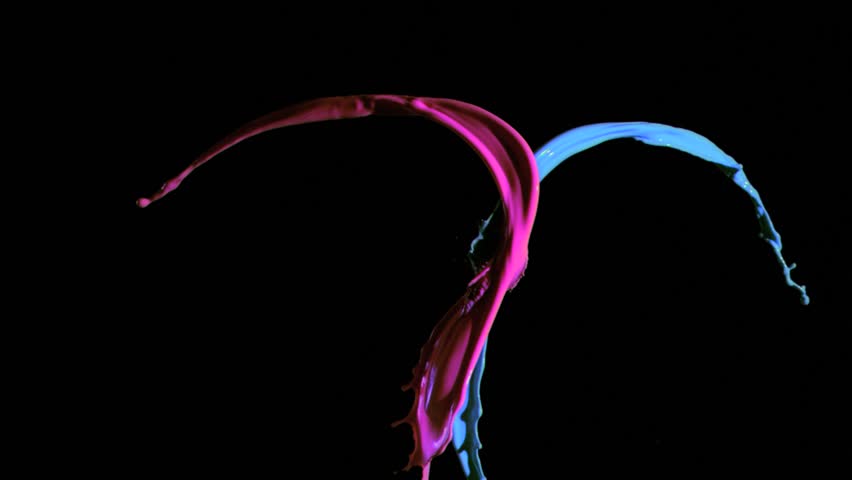 Blue and pink paint in super slow motion being thrown against a black background