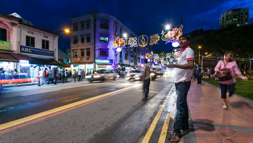 SINGAPORE - 13 NOVEMBER 2012: Night Timelapse of street life in Little India in Singapore. People walking on the sidewalk and traffic can be seen in the scene