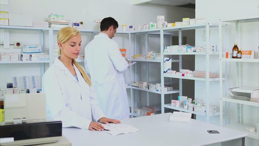 Someone giving a prescription to a pharmacist in a hospital