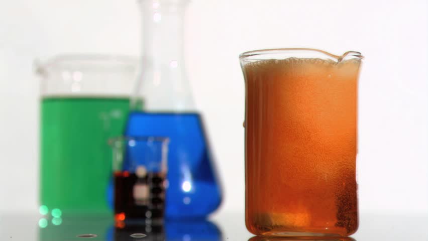 Scientific reaction occurring in super slow motion in a beaker against white background