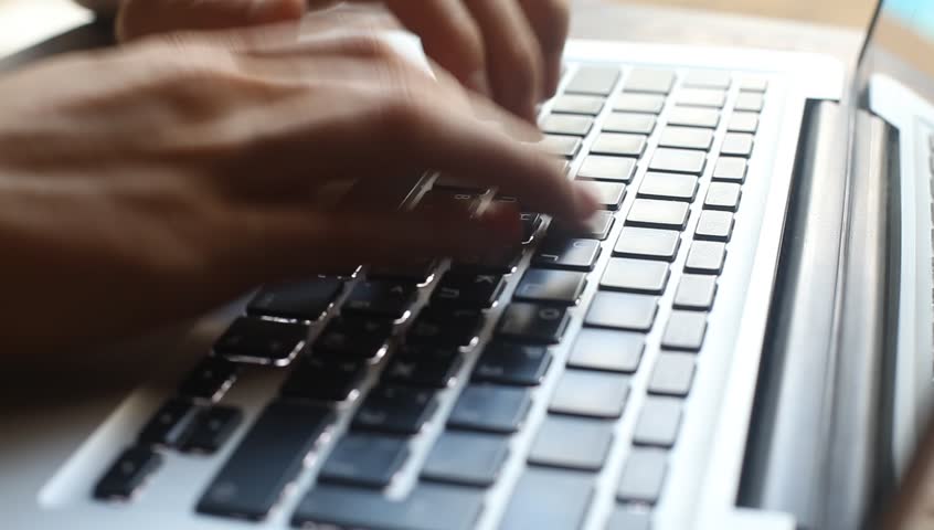 Hands typing on computer keyboard