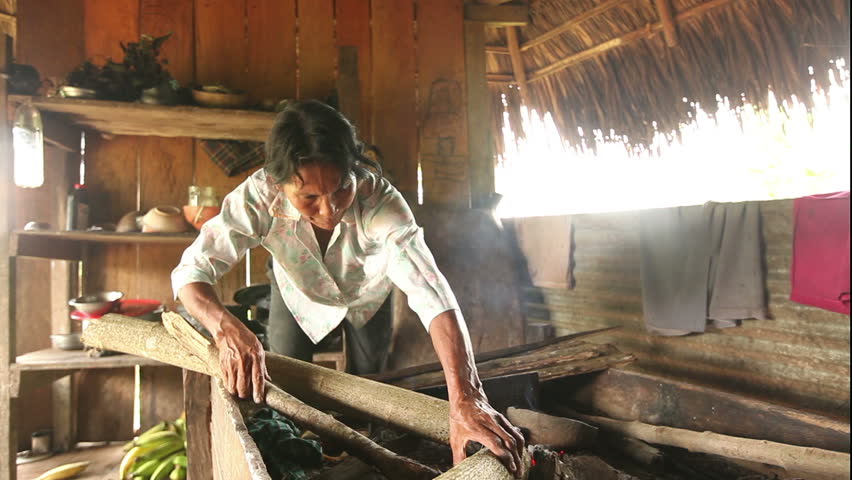 Adult woman making pottery , rural scene in ecuadorian Amazonia. When the desired temperature is reached the pot is covered with ash to prevent cracking an to maintain a constant temperature