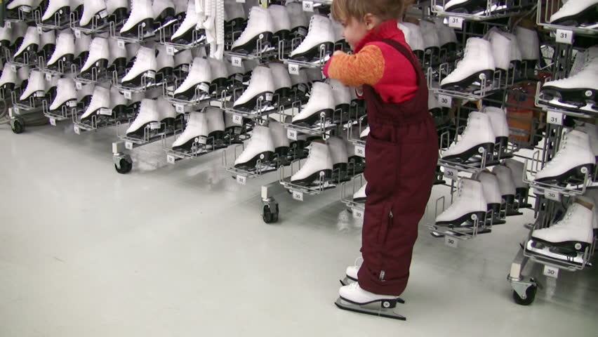 little girl with skates in shop 
