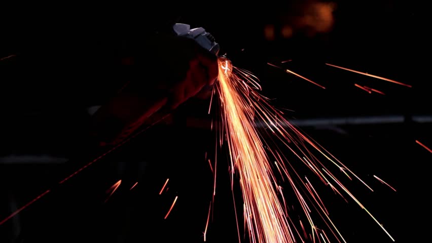 Man working metal. Red sparks.
