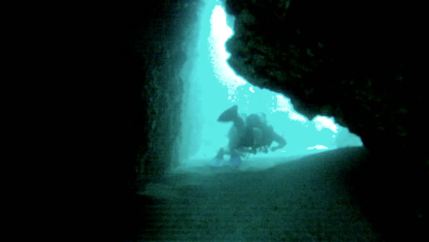 Scuba divers swim through underwater cave Mexico. Friends scuba dive off coast of Puerto Vallarta, Mexico Banderas Bay. Tropical tourism destination for sports, relaxation of warm tropic vacation.