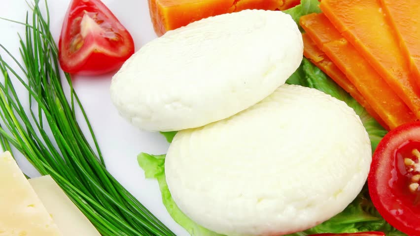 french cheeses : delicatessen aged cheeses with soft feta chops served on white plate with slices isolated on white background