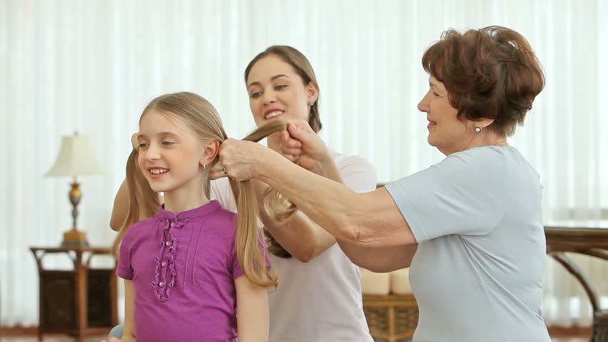 Women of different age braiding the hair of a little cutie