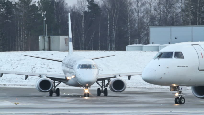 OSLO, NORWAY - DEC 6: Winter, cold weather at OSL Airport, Oslo Norway. Two passenger airplanes ready for takeoff on December 6, 2012.