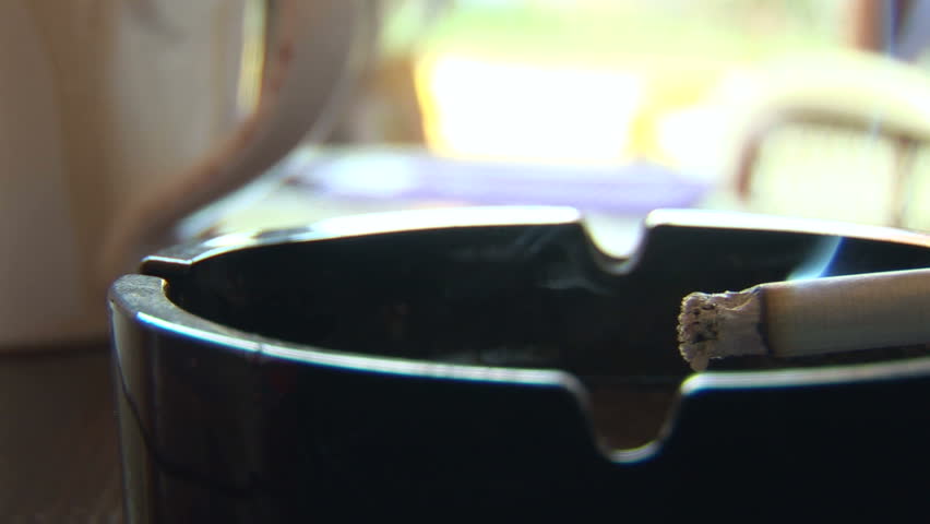 Cigarette and ashtray on a table 

