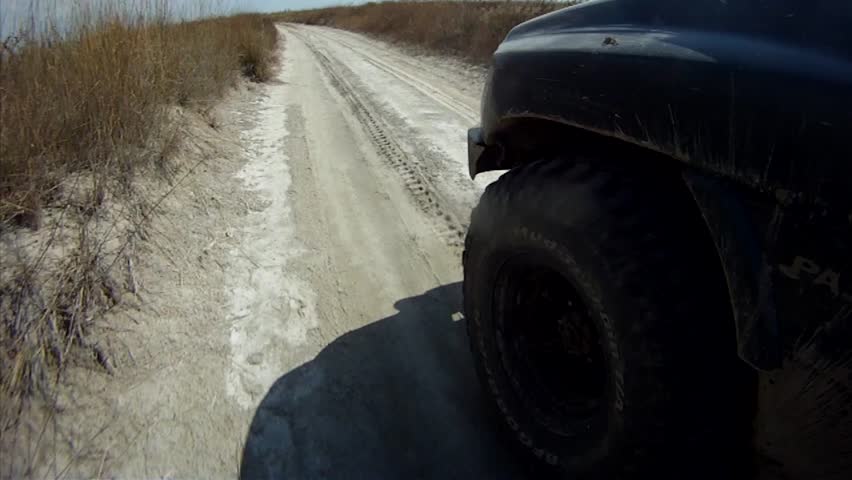 Driving along sandy lowland, wheel view