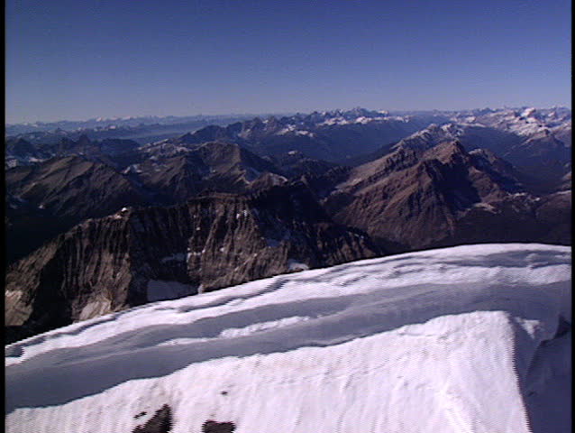 Close fly past large snow cornice on summit ridge of Mount Assinboine in British Columbia Canada