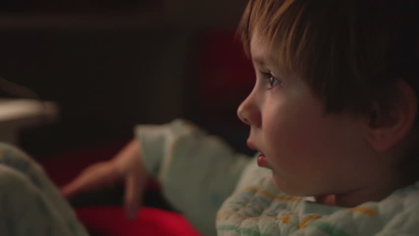 Sony FS-100 - Young boy watching cartoons in a dark room on a computer. 