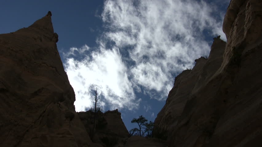 HD time lapse of white clouds moving behind the tall rock and dirt formations at Kasha Katuwe Tent Rocks National Monument