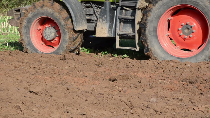 closeup of heavy agricultural machine plough field soil.