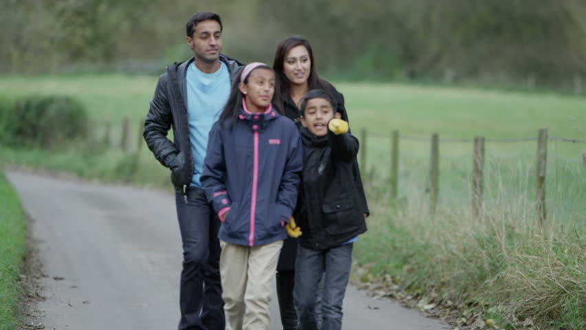 Happy family of 4 enjoying some fresh air and a walk. Slow motion.