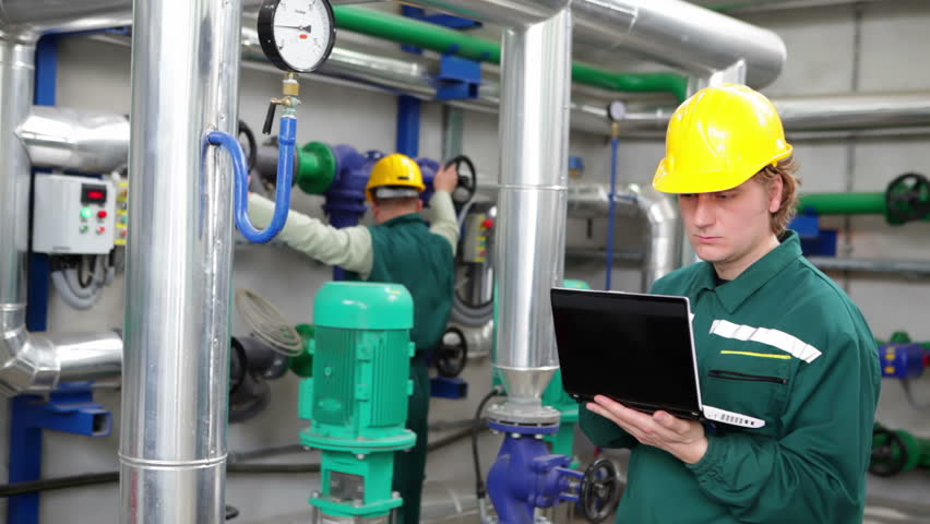 Industrial workers with notebook working in power plant, happy and satisfied teamwork