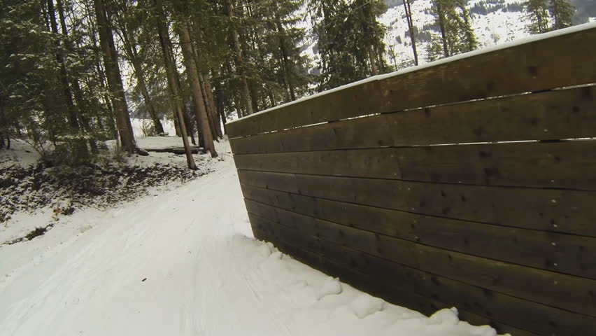 Action cam: slow motion of riding a snow covered track on a snow board therefore somewhat bumpy.