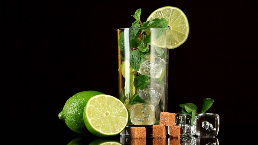 Pouring soda in mojito. Glass, lime, sugar, ice and mint
