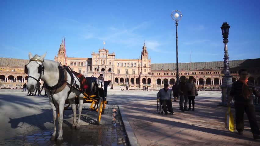 SEVILLE, SPAIN - JANUARY 6: Tourists enjoy a trip on Plaza de Espana, Seville on Jan 6, 2013 It was built in 1928 for the Ibero-American Exposition of 1929 designed by famous architect Anibal Gonzalez