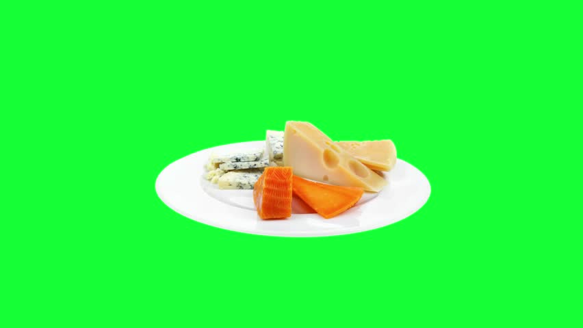 slow motion french delicatessen aged cheeses chops served on white plate with slices on green screen