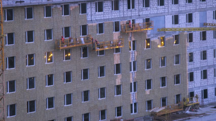 Workers making insulation high-rise building while evening. Timelapse