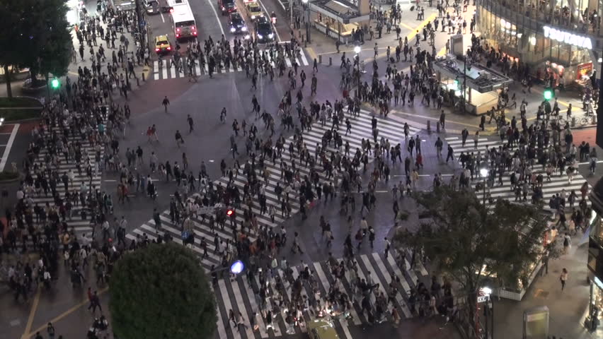 TOKYO, JAPAN - 14 OCTOBER 2012: Large crowds of pedestrians, commuters, and shoppers cross the famous Shibuya intersection at night, in Tokyo, Japan