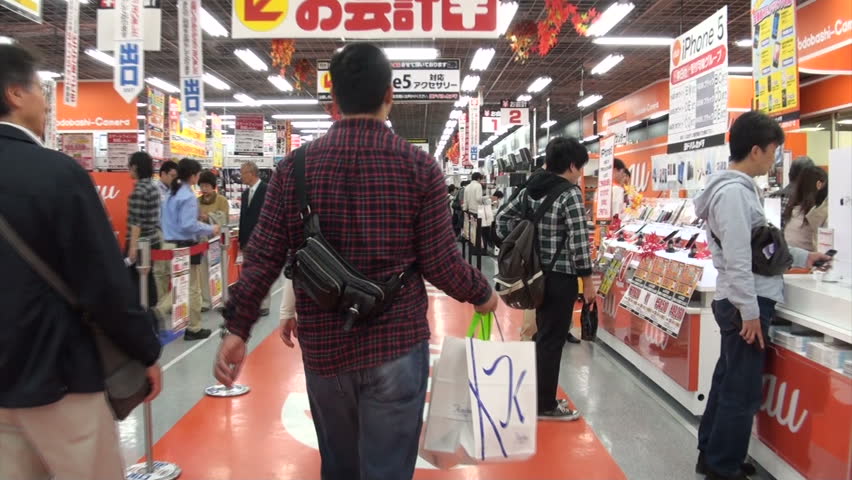 OSAKA, JAPAN - 26 OCTOBER 2012: Handheld video of walking through a busy electronics store where people are looking for computers, phones, TVs and other equipment in Osaka, Japan