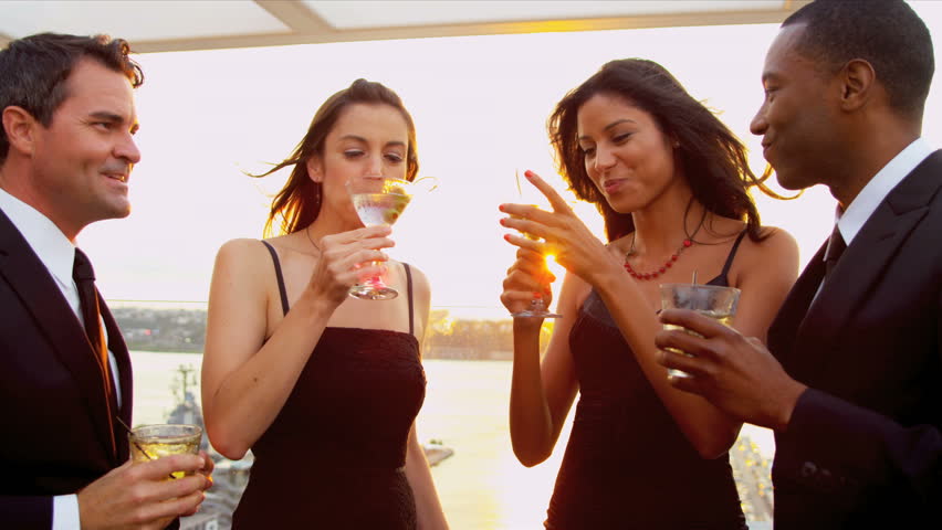 Group of multi ethnic attractive friends chilling and dancing dressed in black at cocktail roof party shot on RED EPIC