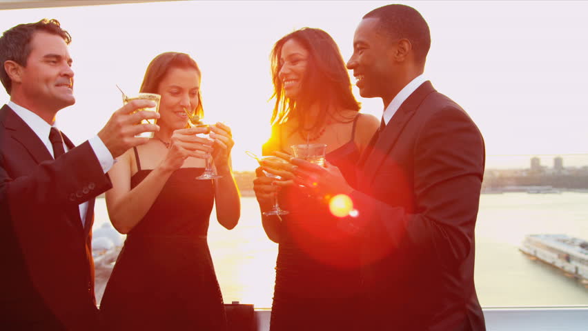 Multi ethnic young attractive women and men laughing and drinking at cocktail roof party dressed in black shot on RED EPIC