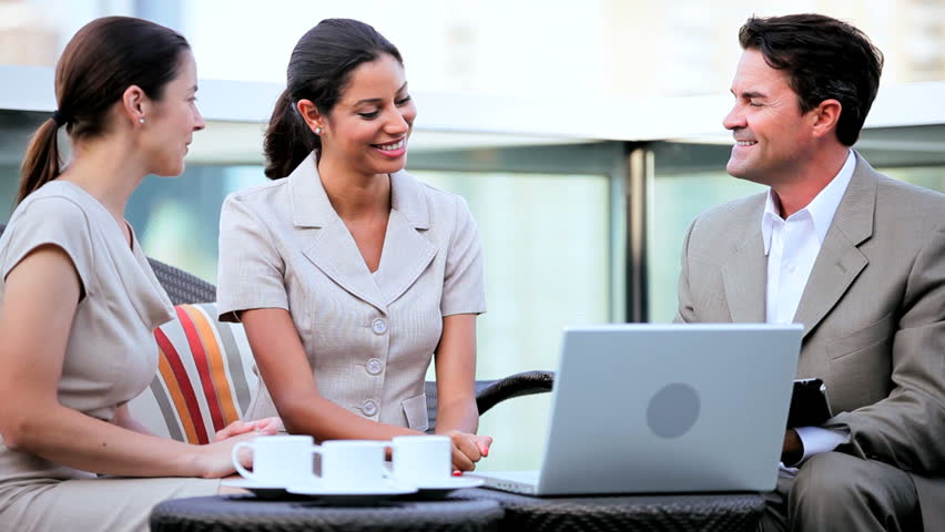 Handshake of diverse business team planning on computers future profit shares outdoors terrace