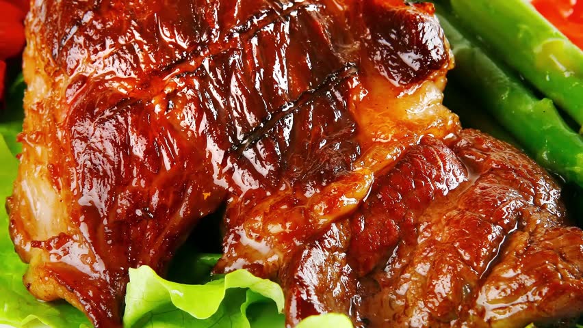 roasted beef meat served with asparagus on plate slow motion  hidef