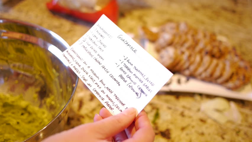 Woman refers to recipe while preparing guacamole