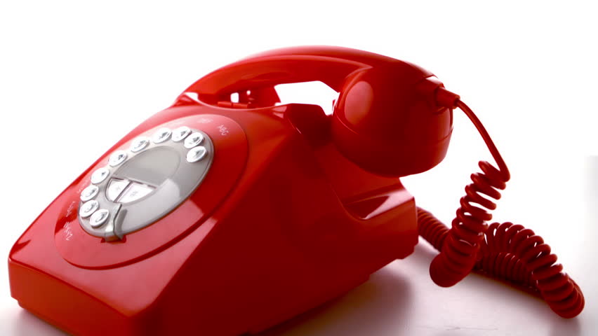 Red phone receiver dropping on dial phone in slow motion
