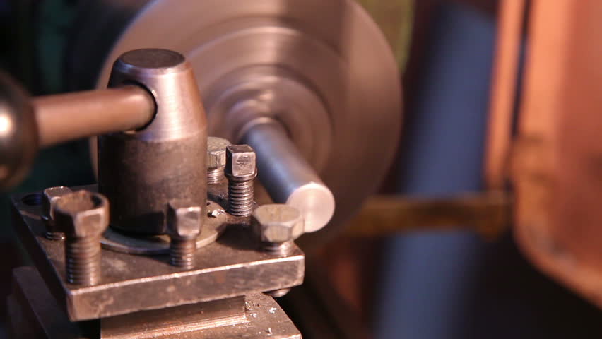 worker handles metal piece on the lathe 6