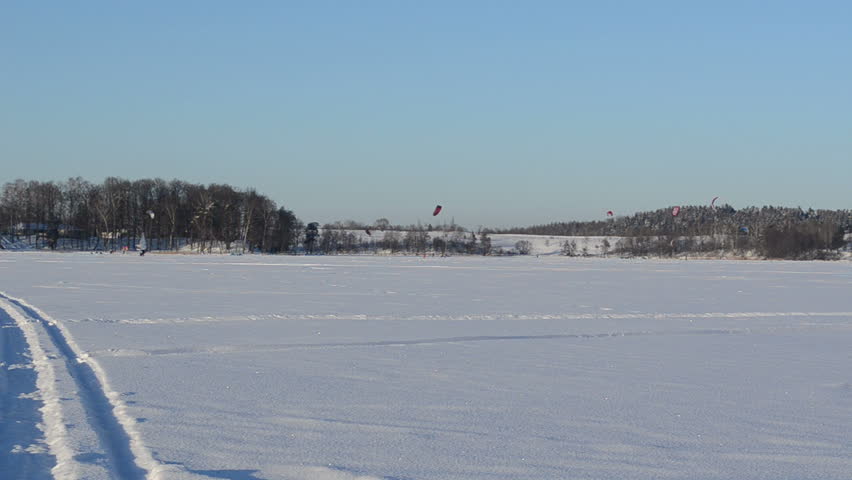 extreme sport action on frozen lake. people kiteboarding and ice sailing surfing. modern recreation hobby.