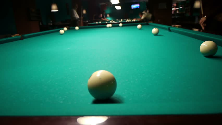 Playing pool, hitting the ball closeup view