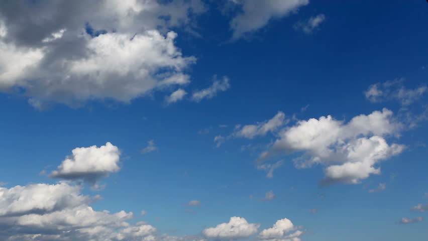 Time lapse clip of white fluffy clouds over blue sky