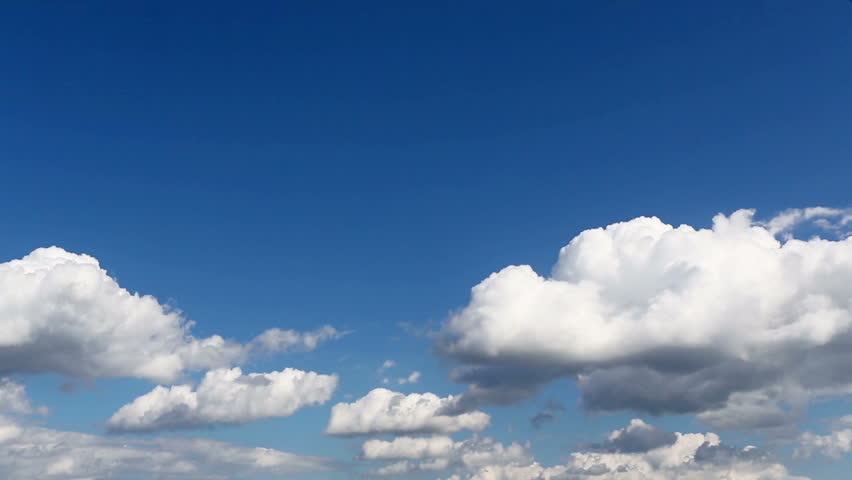 Time lapse clip of white fluffy clouds over blue sky