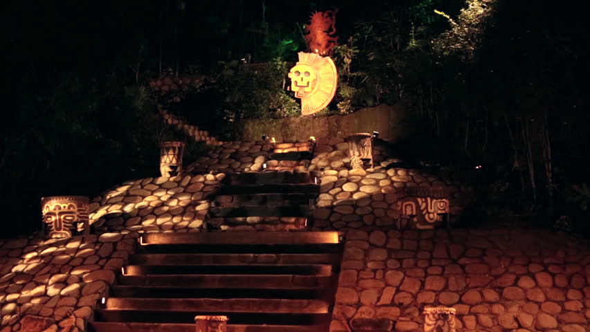Mayan temple pyramid replica night torch flames. Tourism and tourist display of ancient Mayan cultures, costumes and actions.  Portraying ancient inhabitants of Mexico and central America.