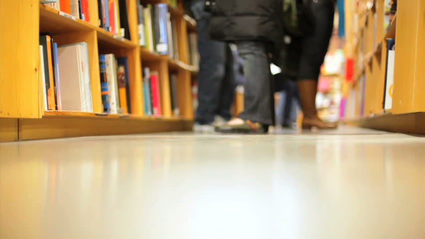 People standing in front of stacks of books, time lapse
