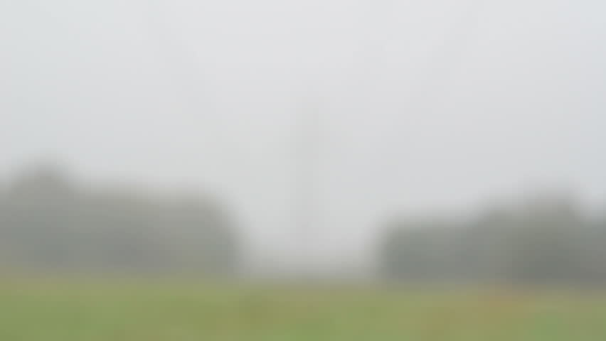 blur view of agriculture field and high voltage electricity pole wire in morning fog.