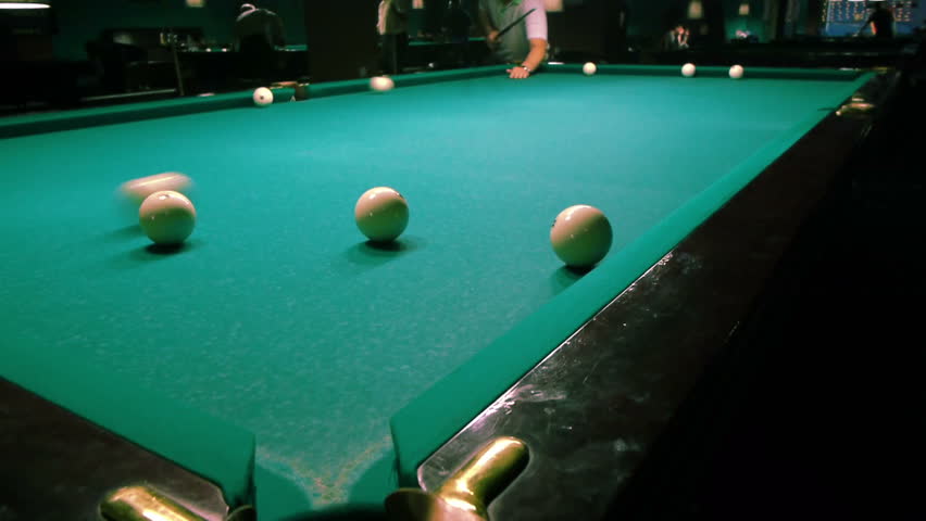 Playing pool, hitting the ball closeup view
