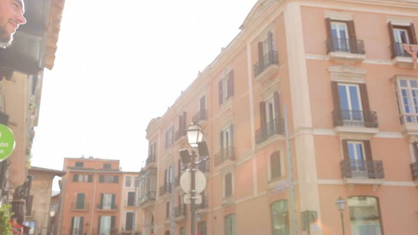 Young couples encounter, hugging and turning in a city street while on vacation.