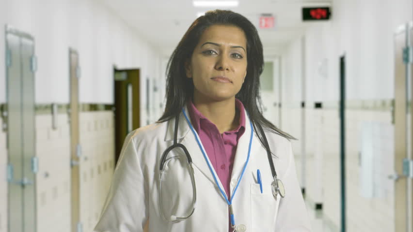 A lovely confident woman physician standing in a hospital hallway.