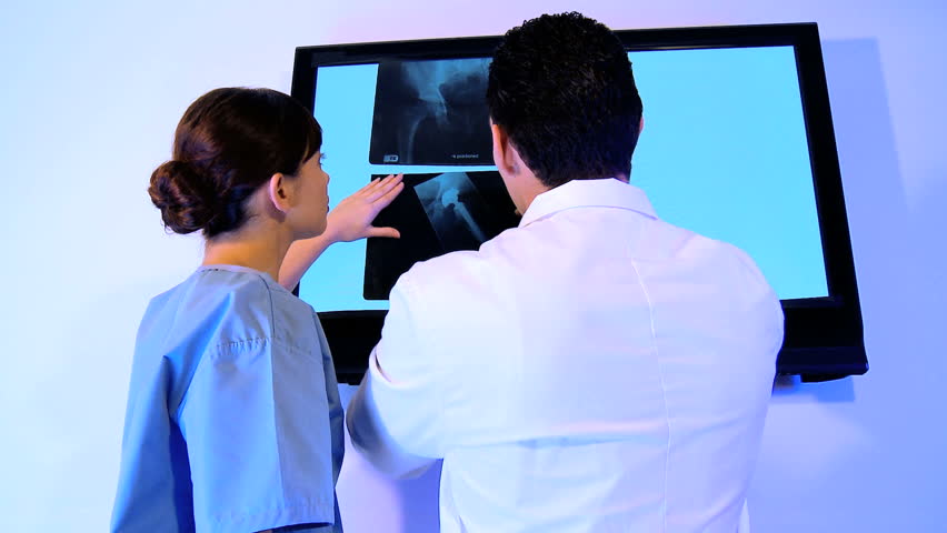 Training doctor & medical student examine patient x-rays
