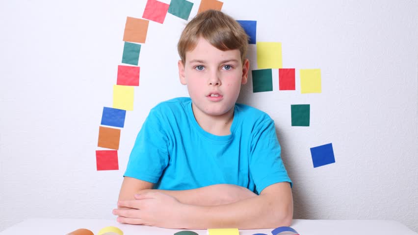 Colored pieces of paper moving around a boy. Stop motion